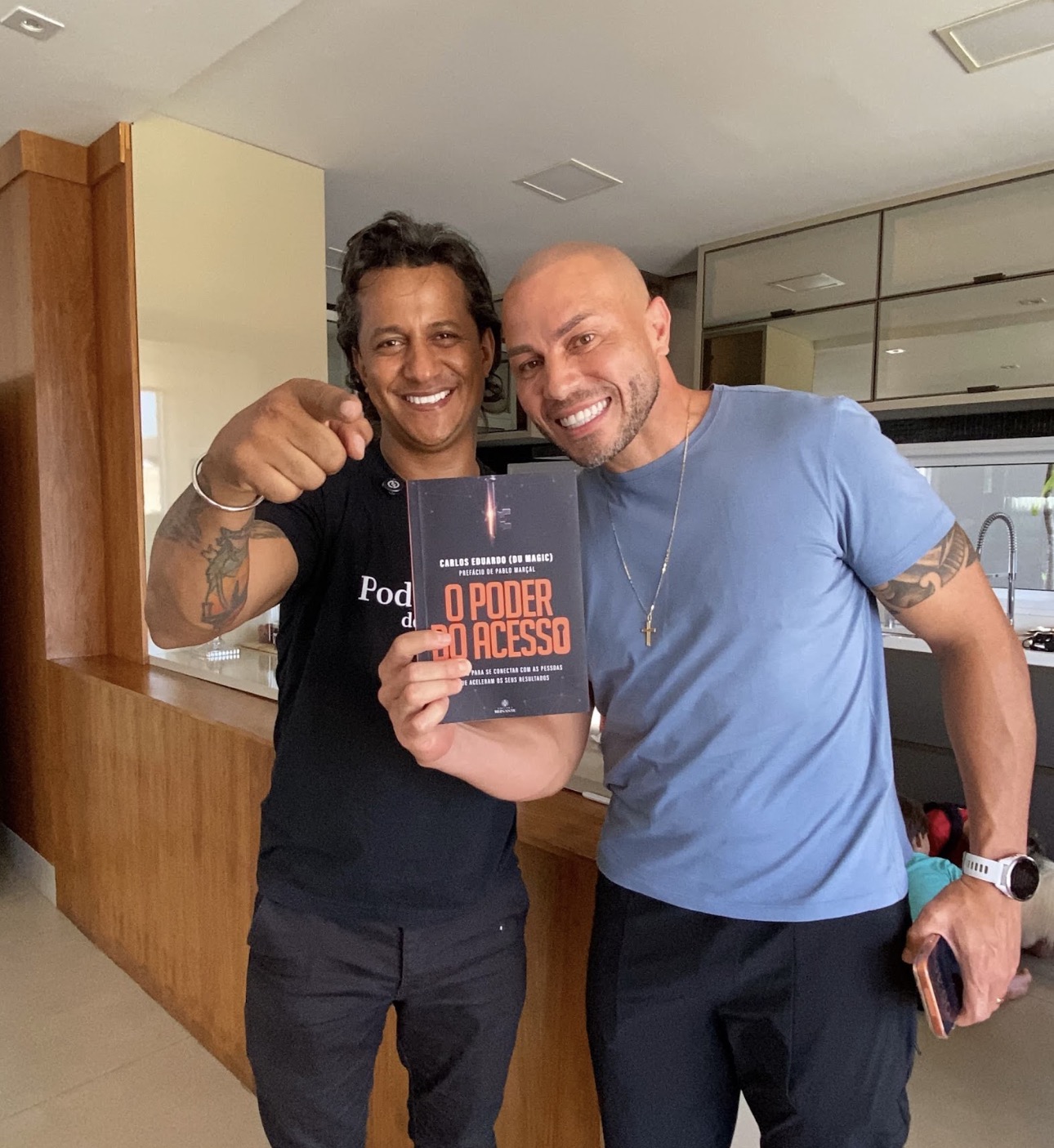 Du Magic ao lado de um leitor segurando o livro O Poder do Acesso